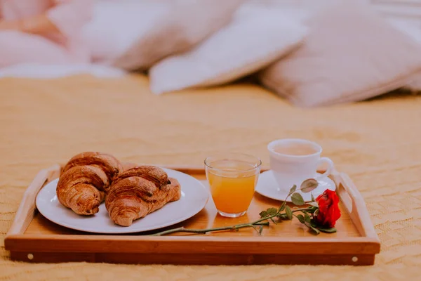 Petit déjeuner au lit, jus d'orange et croissants avec une tasse de café — Photo