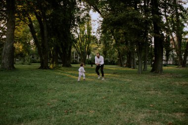 Baba ve oğul yeşil sahada oynamak, koşmak ve eğlenmek