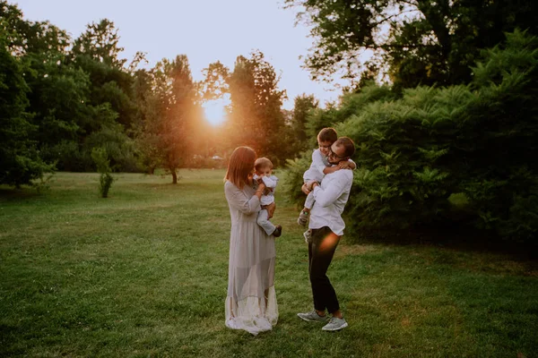 Hermosa familia disfrutando de la vida en un parque en un hermoso día soleado —  Fotos de Stock