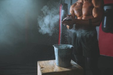 Ayrıntılar closeup vücut geliştirme adam ellerini bir çapraz fitness sınıfında ağırlık kaldırma bir egzersiz başlatmak için hazırlanıyor toz kullanarak