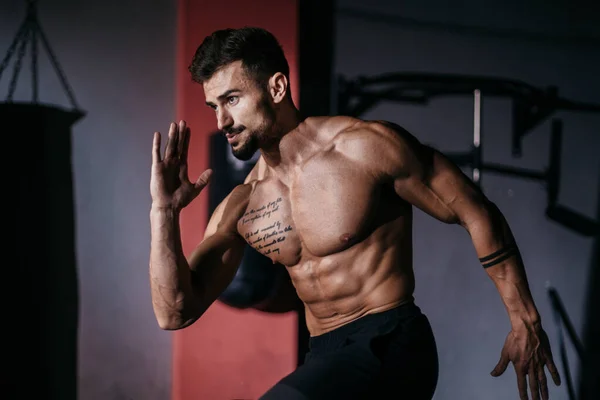 Aantrekkelijke fit body guy neemt de robijn poses dan beginnen te lopen in een cross fitness klasse hij doet een intensieve training — Stockfoto