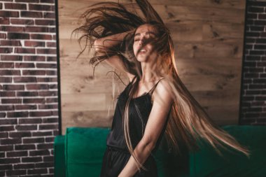 Uzun saçlı, çekici gülüşlü, beyaz dişli, neşeli ve karizmatik bir kadın.