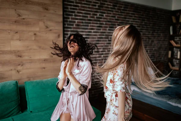 Dançando lindas lindas senhoras de pijama pela manhã aproveitando o momento juntas em um grande apartamento de estúdio com — Fotografia de Stock