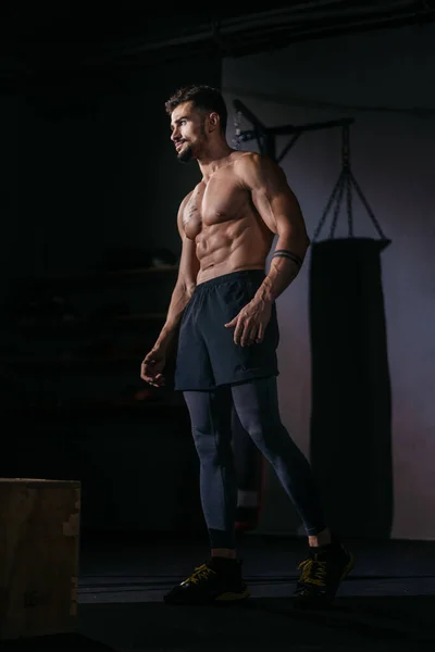 Bodybuilding man portret staande in de voorkant van de camera en poseren in een gym klasse met zwarte achtergrond — Stockfoto