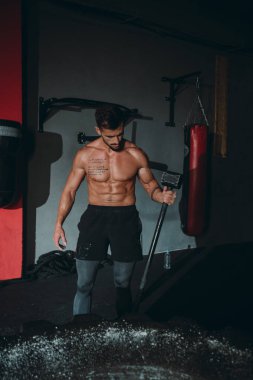 Konsantre olmuş güçlü atletik adam büyük Hummer 'ı kaldırıyor ve beden eğitimi dersinde büyük bir lastik için grev yapmak istiyor.