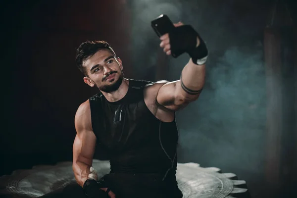 Smiling charismatic athletic man take selfies with his smartphone after the hard workout in a cross fitness class — Stock Photo, Image