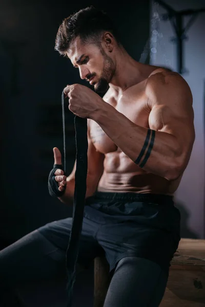 Details close-up bodybuilding concept Guy wikkelt zijn handen met een professionele bandages voorbereiden voor training in de sportschool klasse — Stockfoto
