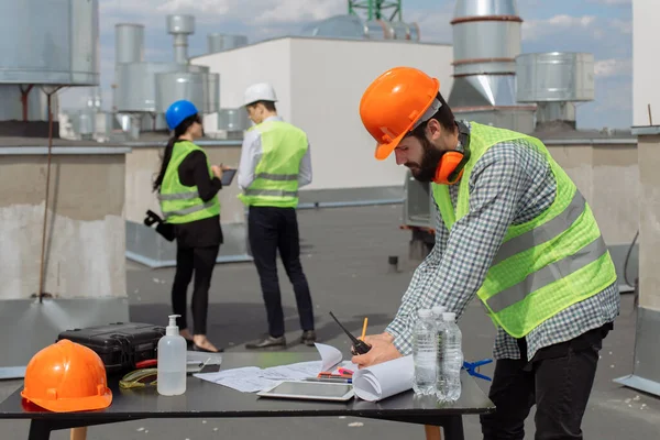 Grupo da indústria da construção civil de engenheiro e arquiteto analisando o plano de construção e folhas com — Fotografia de Stock