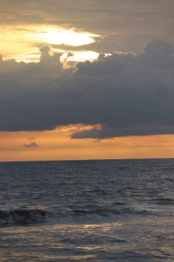 Karamsar bir günde plajın turuncu gökyüzünde berrak beyaz bulutlar