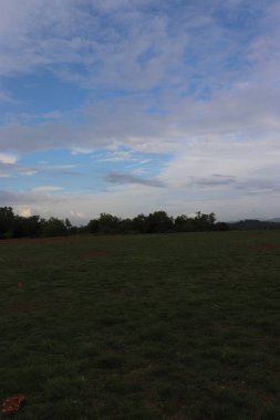 Karamsar bir günde plajın turuncu gökyüzünde berrak beyaz bulutlar