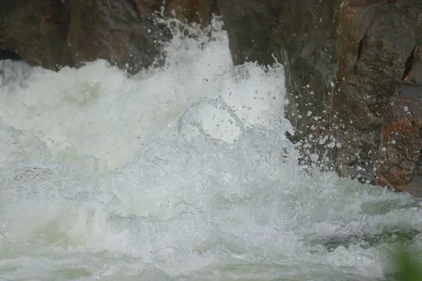 Вода, падающая между камнями с водопадов — стоковое фото