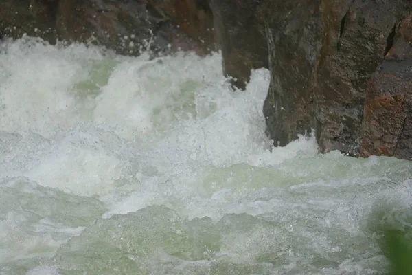 Vatten som faller mellan klipporna från vattenfall — Stockfoto