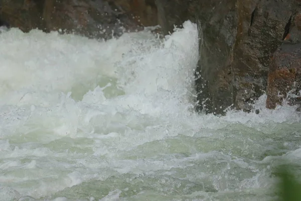 Вода, падающая между камнями с водопадов — стоковое фото