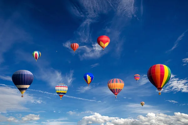 Färgglada varmluftsballonger som flyger över vita moln och blå himmel. — Stockfoto