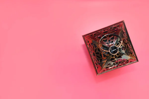 Decorative candlestick top view on a pink background