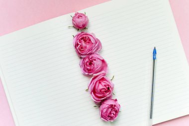 Açık defter, çiçekler pembe arka plan. Model yap. Kartpostal şablonu. Metin için yer