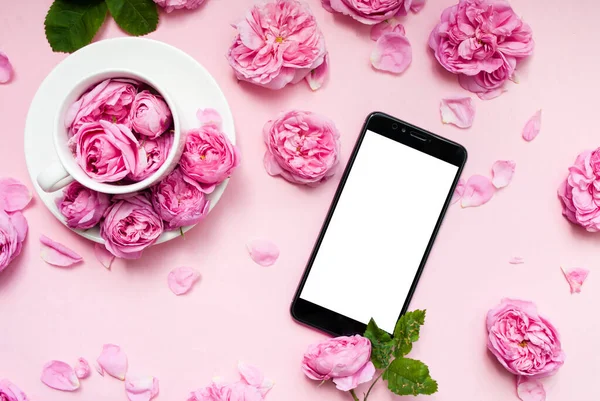 Mobile phone, pink flowers pink background. Place for text. Festive background. Mock up. Postcard template. Congratulation. Morning concept.
