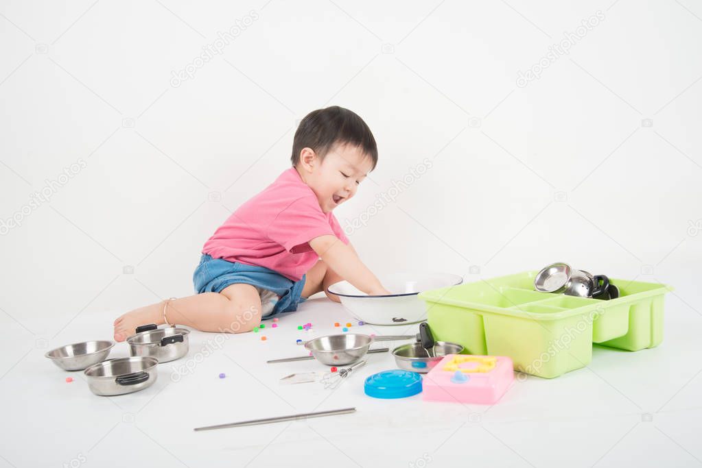 Little Asian toddler 2 years old playing kitchen toy 