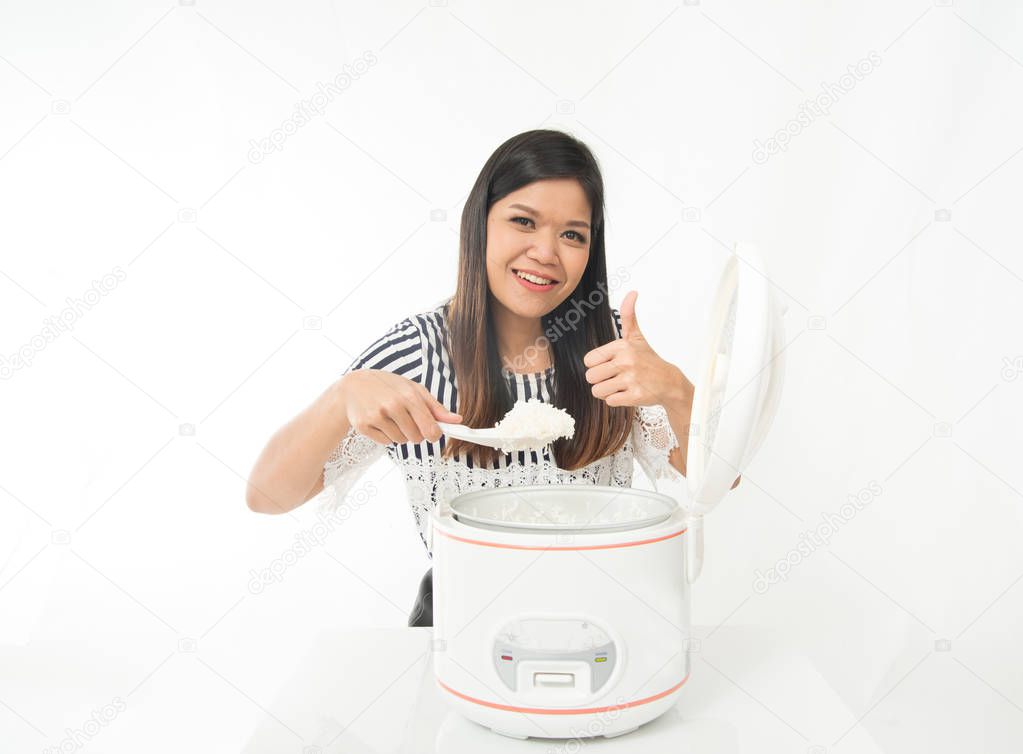 Asian woman use a rice cooker cook for meal in the kitchen