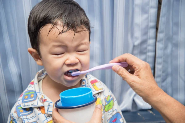 Grand mother\'s hand brush teeth for baby boy toddler morning time