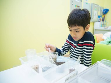 Çocuk fen bilgisi dersinde şişe küçük ağaç bitki