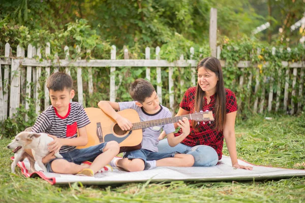 シングルマザーと息子遊ぶ公園で楽しい Guitartogether — ストック写真