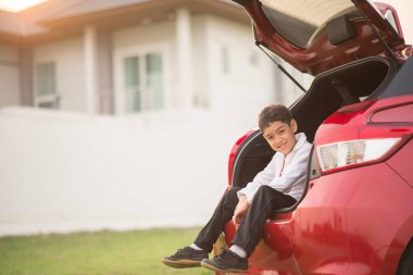 Küçük çocuk ahnd dalga ile otomobilin arka kapısında oturan