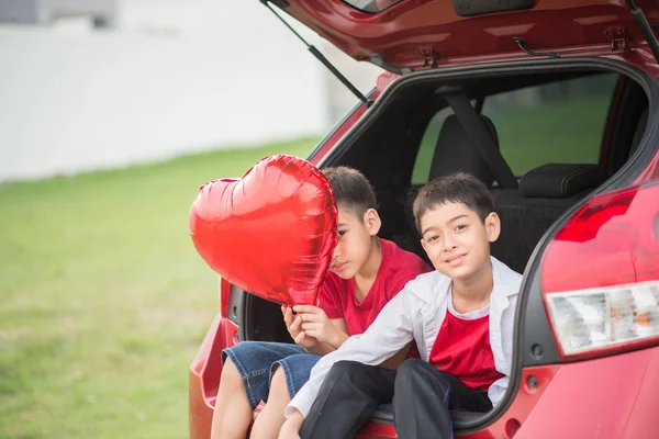 Arka Kapıyı Balon Kalp Ile Aracın Oturan Küçük Çocuklar — Stok fotoğraf