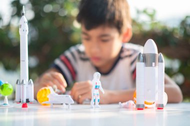 Uzay gemisi ve gezegen gökada oyuncak oynarken küçük çocuk 