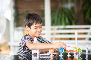 Uzay gemisi ve gezegen gökada oyuncak oynarken küçük çocuk 