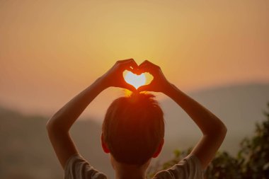 Tepenin arkasında gündoğumu sabah isteyen küçük çocuk