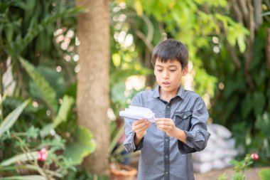 Parkta kağıt roket oynarken küçük çocuk