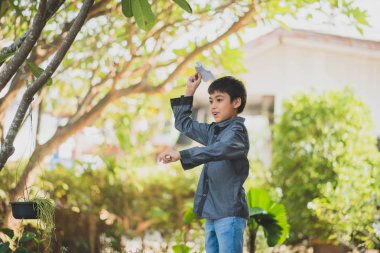 Parkta kağıt roket oynarken küçük çocuk