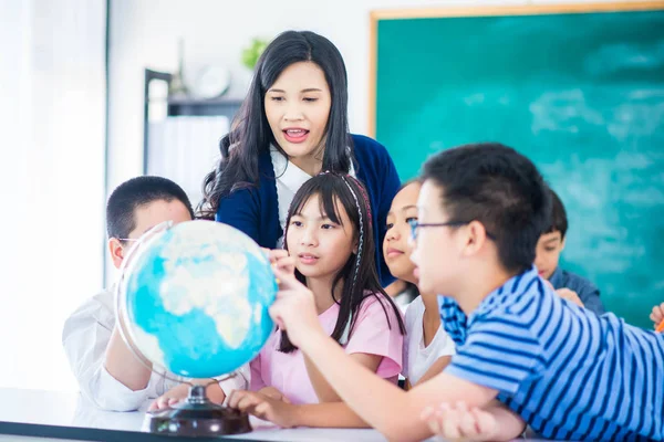 Portraitschülerin Blickt Auf Globus Und Hört Lehrerin Mit Lupe — Stockfoto