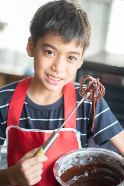 Little boy baking chocolate cake homemade