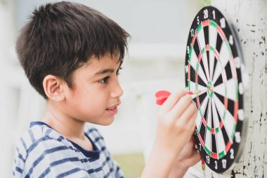 Küçük çocuk dart kurulu aile açık hava etkinliği oynarken 