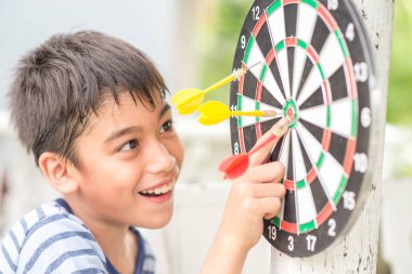 Küçük çocuk dart kurulu aile açık hava etkinliği oynarken 