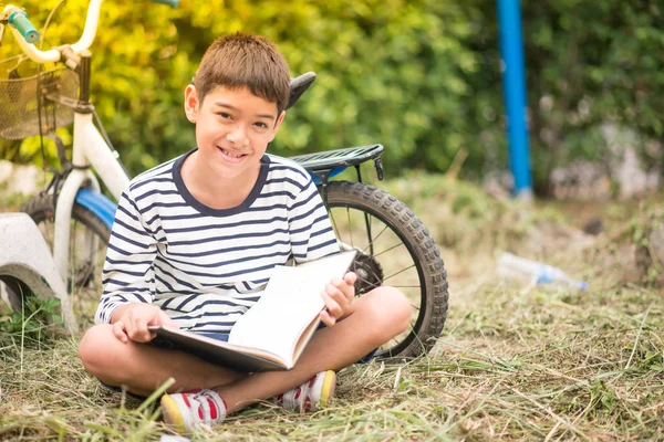 Parkta Bisikletle Oturan Küçük Çocuk Kitap Okuyor — Stok fotoğraf