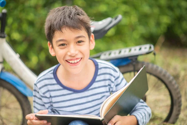 Lilla Pojke Läsning Bok Sitter Med Cykel Parken — Stockfoto