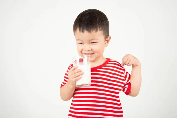 幸せな顔でグラスからミルクを飲む小さなアジアの少年 — ストック写真
