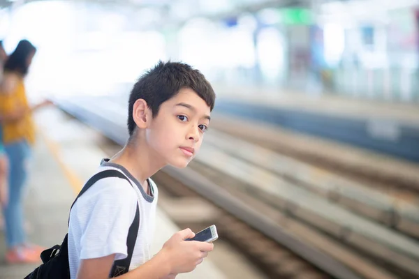 Küçük Öğrenci Çocuk Elinde Mobil Ile Platformda Tren Bekliyor — Stok fotoğraf