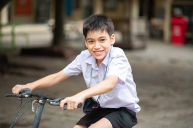 Okulda bisiklete binen öğrenci.