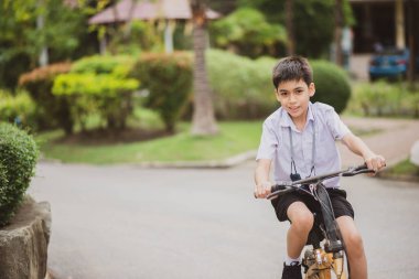 Okulda bisiklete binen öğrenci.