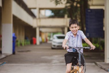 Okulda bisiklete binen öğrenci.