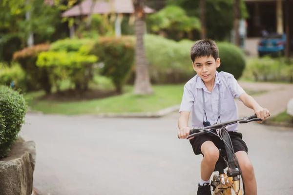 学校で自転車に乗る学生少年 — ストック写真