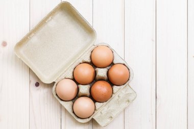 Bir karton bir ahşap masa üstüne yumurta