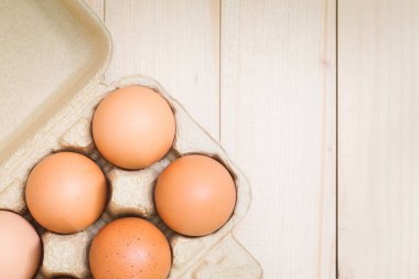 Bir karton bir ahşap masa üstüne yumurta