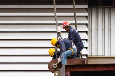 Ağır çelik tel halatile çalışan işçiler