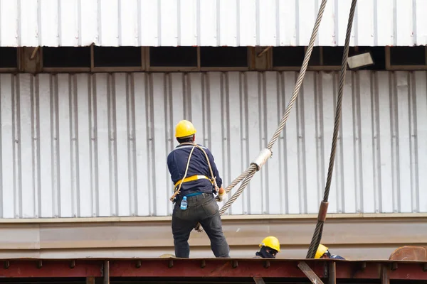 Worker pulling heavy duty steel wire — Stock Photo, Image