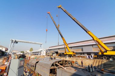 Kuru rıhtım üzerinde çalışan iki kamyon vinçler gemi gövde par kaldırıyor